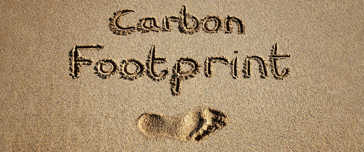 Carbon,Footprint,Written,In,Sand,On,A,Beach.